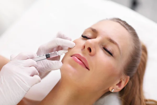 Närbild på händerna på kosmetolog att göra botox injektion i kvinnliga läppar — Stockfoto