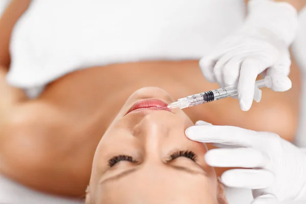 Primer plano de las manos del cosmetólogo que hace la inyección de botox en los labios femeninos —  Fotos de Stock