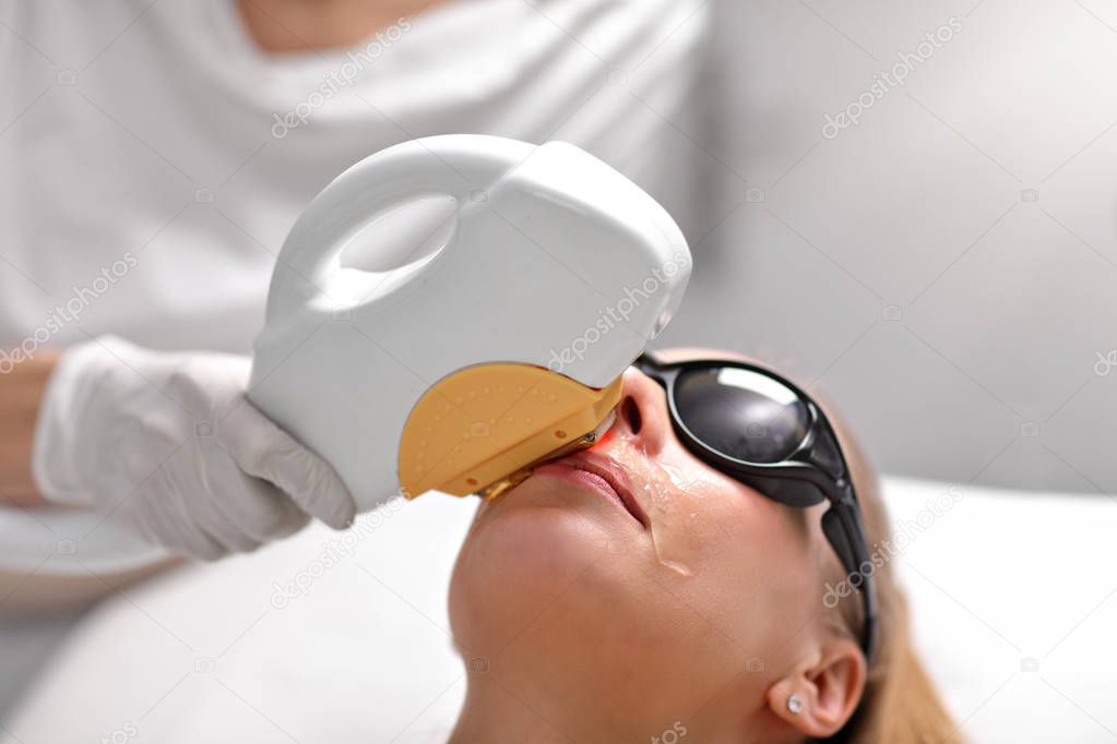 Beautician Giving Epilation Laser Treatment To Woman On Face