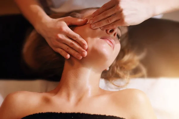 Mujer feliz teniendo masaje facial en el salón de spa —  Fotos de Stock