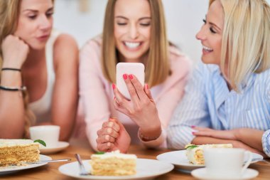 Akıllı telefon kullanarak mutlu arkadaş grubunu sunan resim