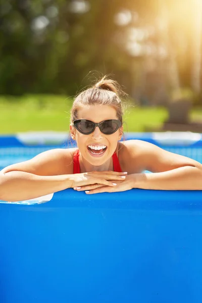 Vue rapprochée d'une femme séduisante se relaxant sur la piscine dans le jardin — Photo