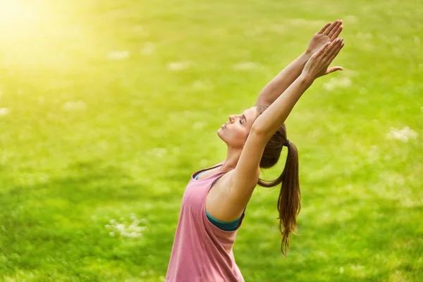 Giovane donna che fa yoga nel parco — Foto Stock