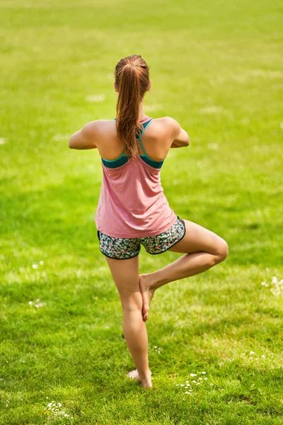 Mujer joven haciendo yoga en el parque — Foto de Stock