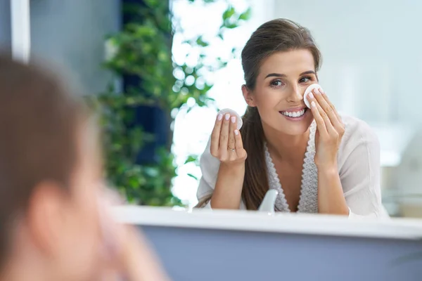 Schöne brünette Frau Reinigung Gesicht im Badezimmer — Stockfoto