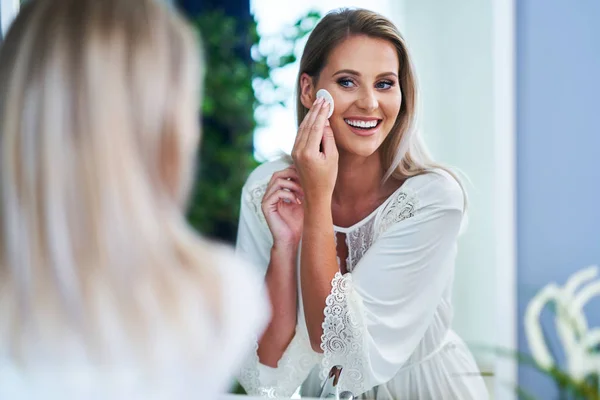 Mooie brunette vrouw schoonmaak gezicht in de badkamer — Stockfoto