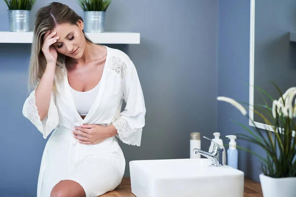 Young woman feeling unwell in bathroom — Stock Image Young woman feeling unwell in bathroom Royalty Free Stock Photos