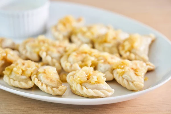 Gnocchi fritti ripieni di carne cipolla carmelizzata su piatto bianco — Foto Stock