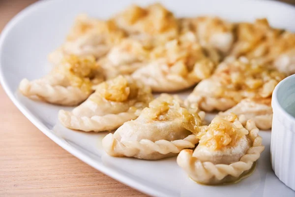 Gnocchi fritti ripieni di carne cipolla carmelizzata su piatto bianco — Foto Stock