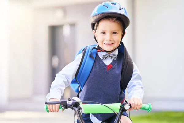 School boy in safety helmet riding bike with backpack — Stock Photo, Image