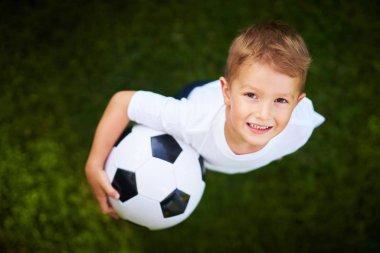 Little Boy practising soccer outdoors clipart