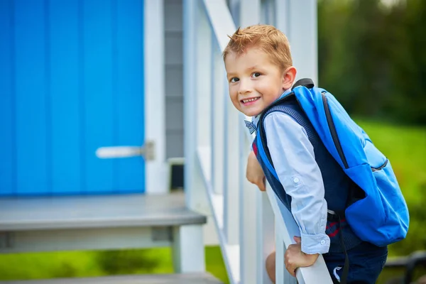 Щасливий маленький дошкільний хлопчик з рюкзаком позує на відкритому повітрі — стокове фото