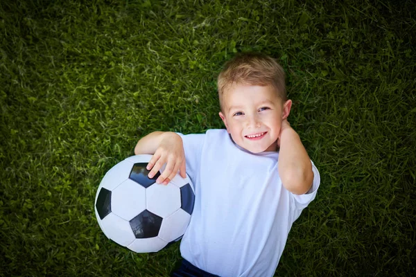 Liten pojke som utövar fotboll utomhus — Stockfoto