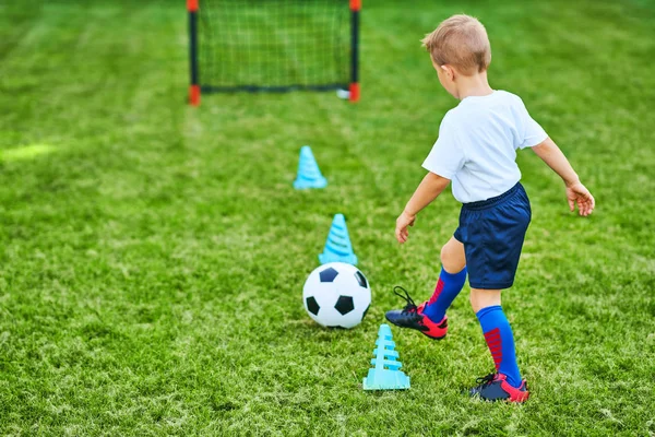 Kleine jongen beoefenen voetbal buitenshuis — Stockfoto