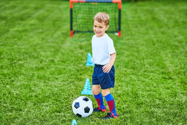 Little Boy praktykanie piłki nożnej na zewnątrz — Zdjęcie stockowe