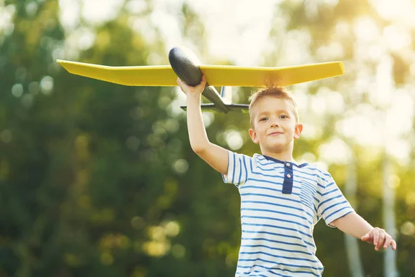 Feliz niño de 3 años que se divierte jugando con el avión grande al aire libre —  Fotos de Stock