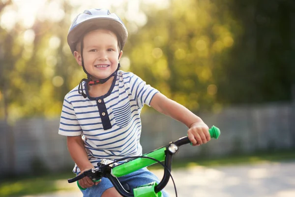 Happy 3 year old boy having fun riding a bike — Stock Photo, Image