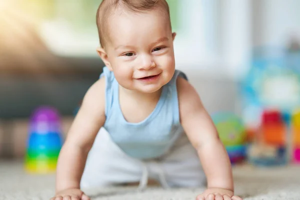 Cute smiling baby boy crawling on floor in living room — Stock Photo, Image