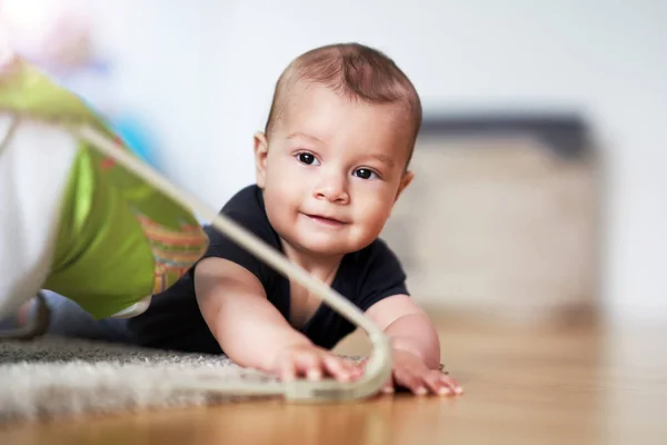 Cute smiling baby boy crawling on floor in living room — Stock Photo, Image