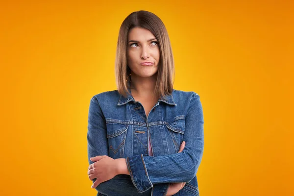 Ongelukkige vrouw in denim jasje over gele achtergrond — Stockfoto