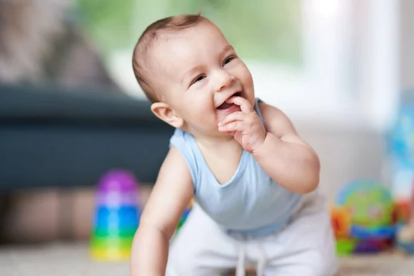 Cute smiling baby boy crawling on floor in living room — Stock Photo, Image