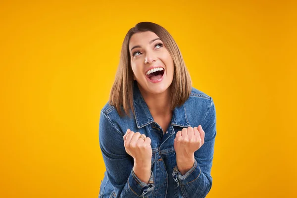 Close up de mulher bem sucedida em jaqueta de ganga sobre fundo amarelo — Fotografia de Stock