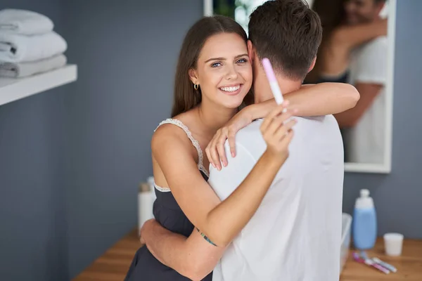 Portret van gelukkig jong stel met zwangerschapstest in de badkamer — Stockfoto