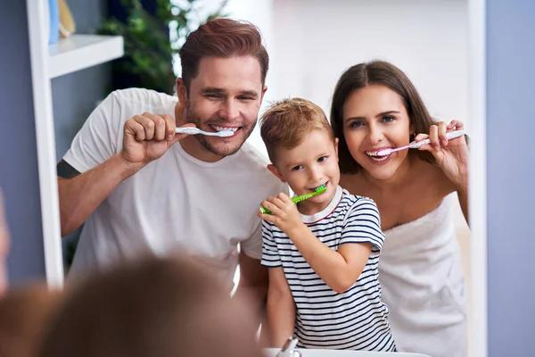 Portrait de famille heureuse brossant les dents dans la salle de bain — Photo