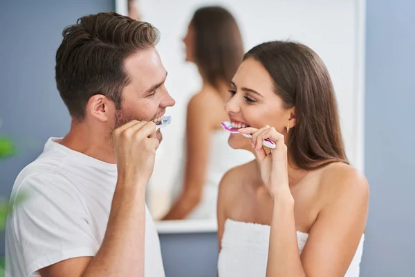 Retrato de feliz casal jovem escovando dentes no banheiro — Fotografia de Stock