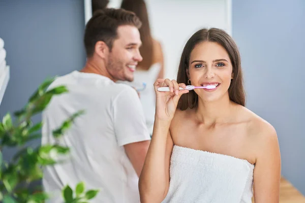 Retrato de pareja joven y feliz cepillándose los dientes en el baño — Foto de Stock