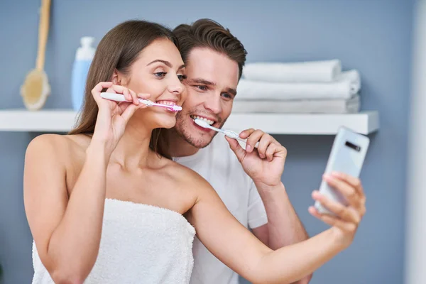 욕실에서 치아를 닦는 행복한 젊은 부부의 초상화 — 스톡 사진