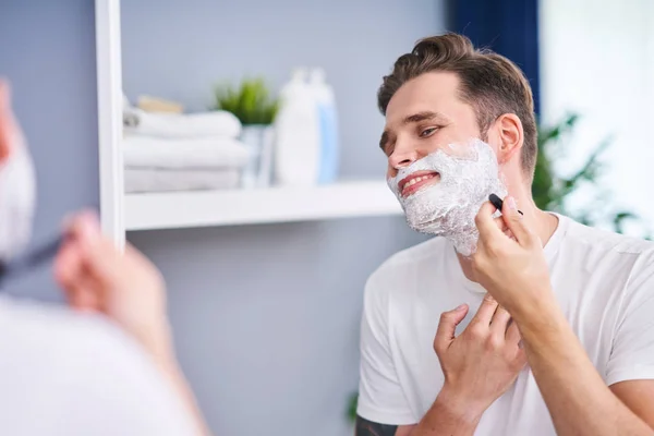 Portrait of adult man shaving in the bathroom — Stock Photo, Image