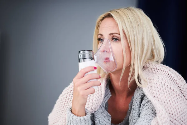 Yetişkin kadın unewll duygu ve evde inhaler kullanarak — Stok fotoğraf