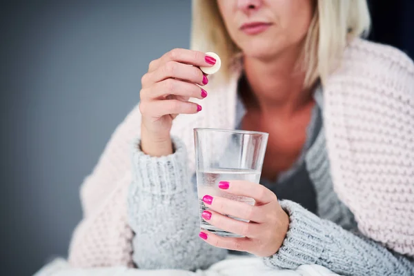 Volwassen vrouw gevoel unewll en het nemen van tabletten thuis — Stockfoto