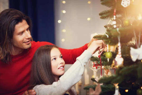 Hermosa familia decorando el árbol de Navidad en casa —  Fotos de Stock