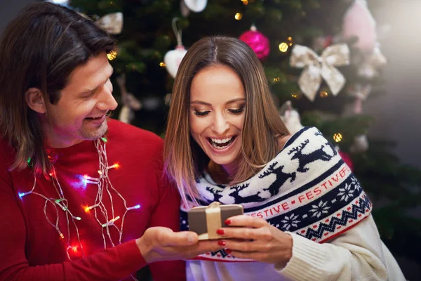Vackra vuxna par med nuvarande över julgran — Stockfoto
