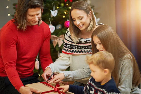 Mooie familie met cadeautjes over kerstboom — Stockfoto