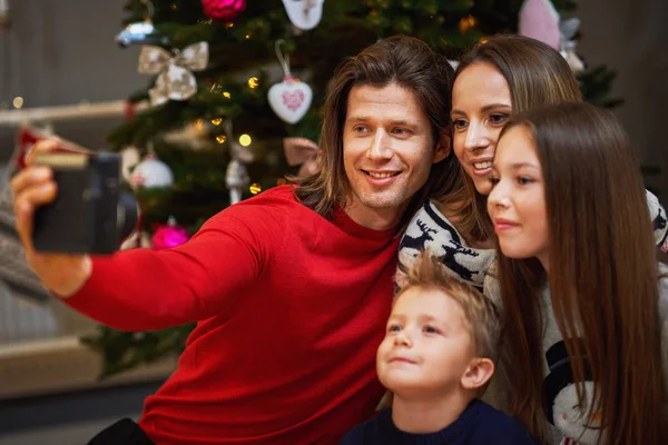 Bela família celebrando o Natal em casa e tirando fotos instantâneas — Fotografia de Stock