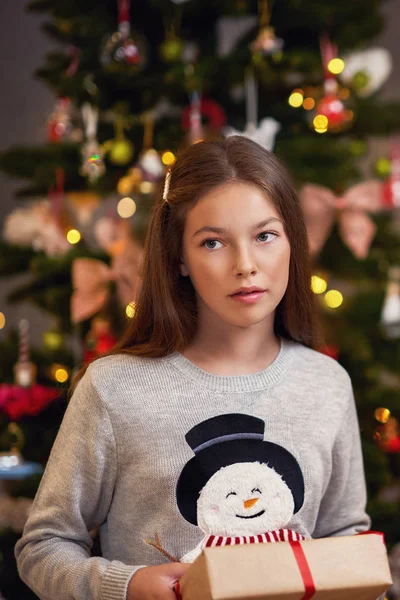Hermosa chica con regalo sobre el árbol de Navidad —  Fotos de Stock