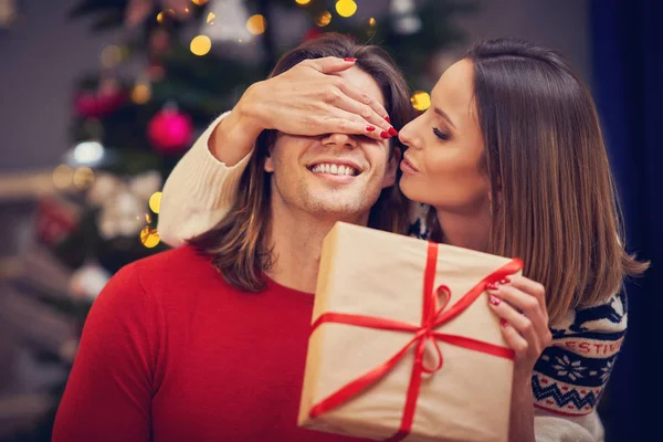 Belo casal adulto com presente sobre a árvore de Natal — Fotografia de Stock