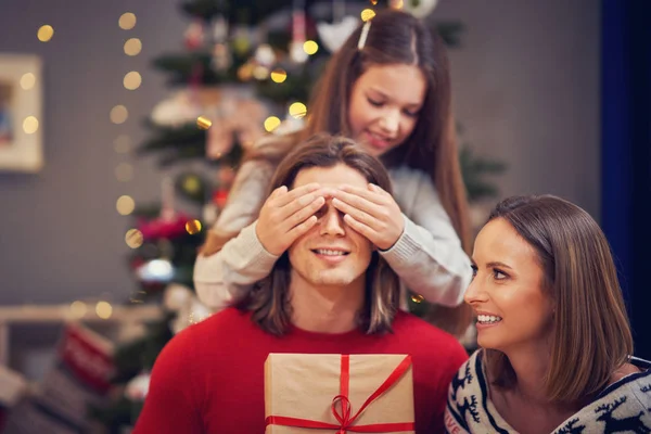 Vacker familj med presenter över julgran — Stockfoto