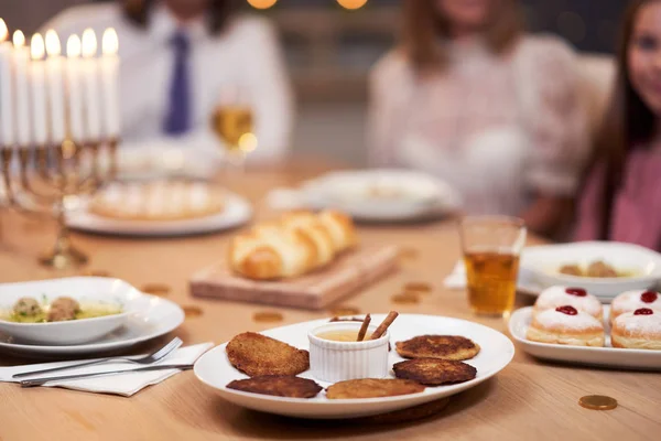 Jantar Hanukkah. Família reunida em torno da mesa com pratos tradicionais — Fotografia de Stock