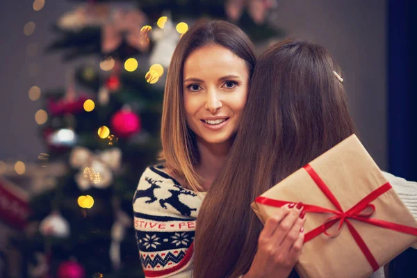 Matka a dcera s dárky přes vánoční stromek — Stock fotografie