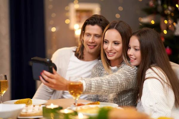 Hermosa familia celebrando la Navidad en casa y tomando fotos instantáneas —  Fotos de Stock