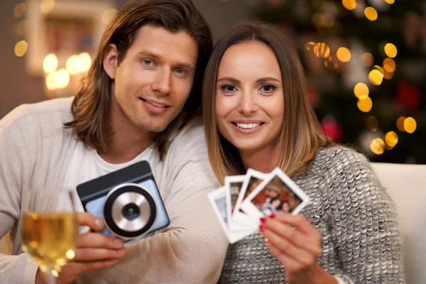 Hermosa pareja celebrando la Navidad en casa y tomando fotos instantáneas —  Fotos de Stock