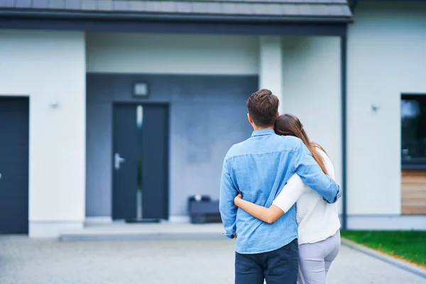 Couple in front of one-family house in modern residential area — Stock Photo, Image