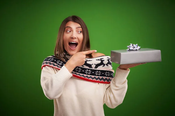 Adult happy woman with Christmas gift over green background — Stock Photo, Image