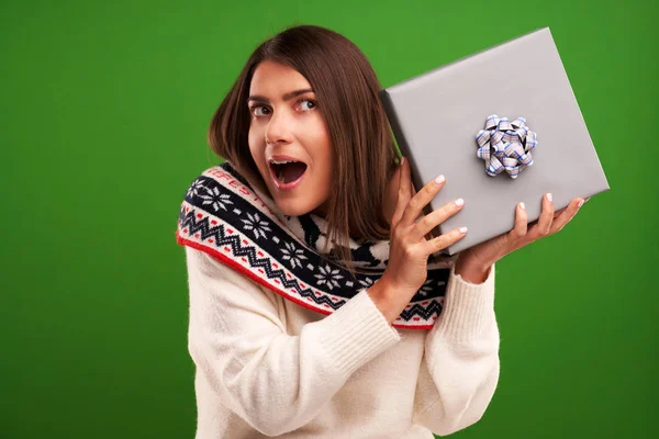 Erwachsene glückliche Frau mit Weihnachtsgeschenk über grünem Hintergrund — Stockfoto