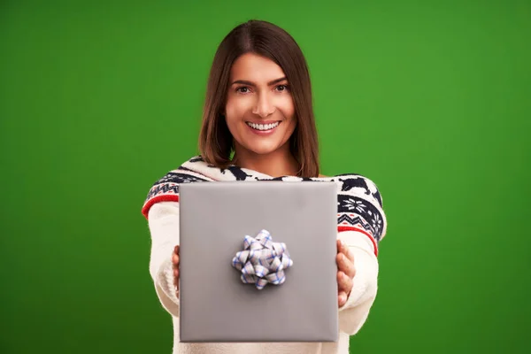 Взрослая счастливая женщина с подарком на Рождество на зеленом фоне — стоковое фото