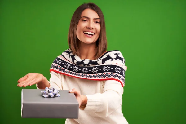 Erwachsene glückliche Frau mit Weihnachtsgeschenk über grünem Hintergrund — Stockfoto